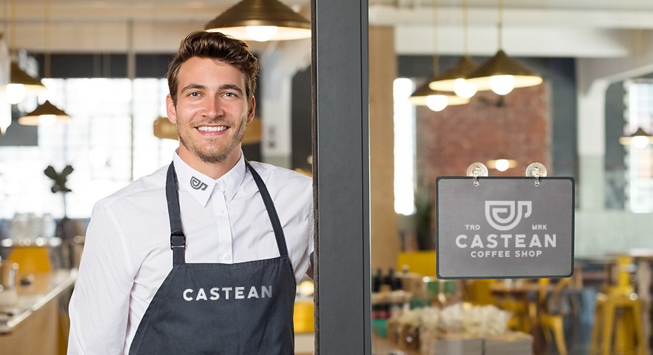 Corporate Fashion: ein Styleguide, zu sehen ist ein Mann mit Schürze, der einladend im Eingang eines Cafés steht