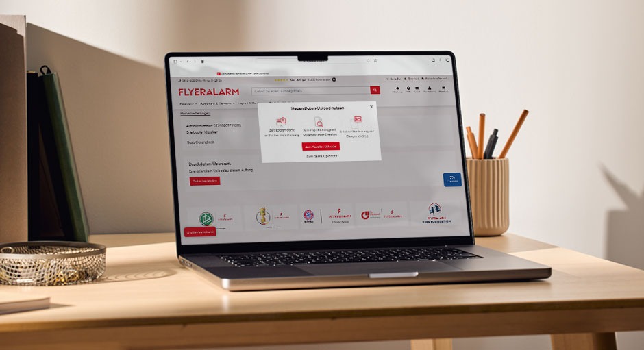 Auf einem Laptop ist zu sehen, wie Daten bei FLYERALARM hochgeladen werden.
