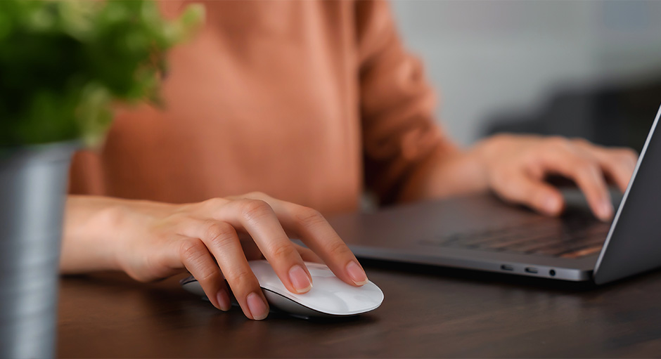 Nachaufnahme einer Person am PC mit Fokus auf den Händen