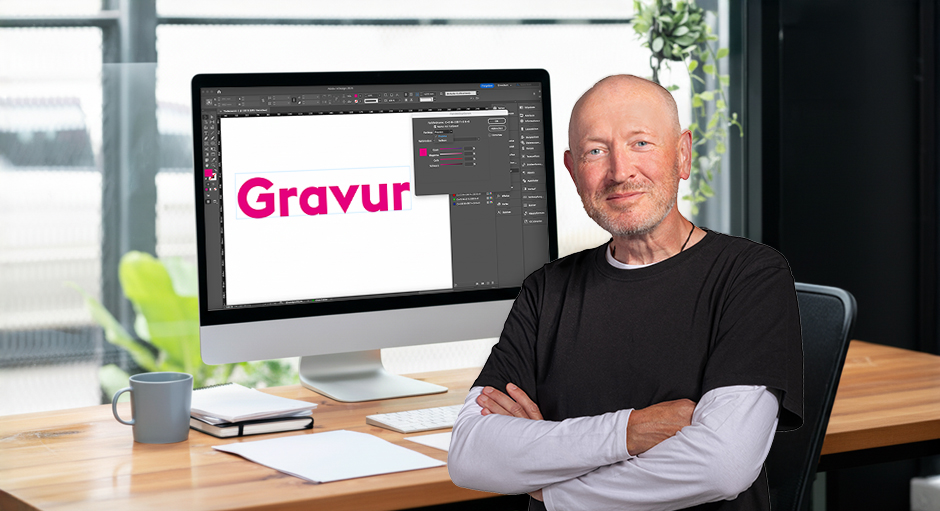 Andreas von FLYERALARM vor einem Bildschirm-Arbeitsplatz mit dem Wort Gravur