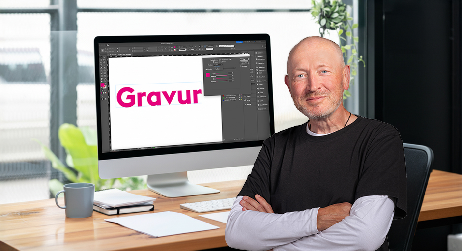 Andreas von FLYERALARM vor einem Bildschirm-Arbeitsplatz mit dem Wort Gravur