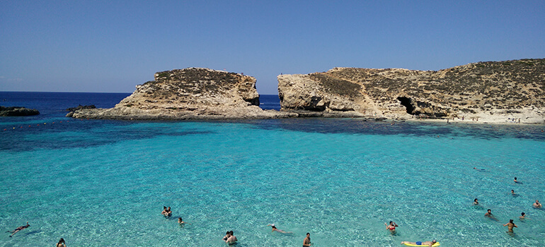 Blick auf türkisblaues Meer und Felsen vor der Küste von Malta.