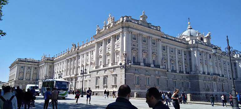 Historisches Gebäude in Madrid mit vielen Verzierungen, Menschen im Vordergrund.
