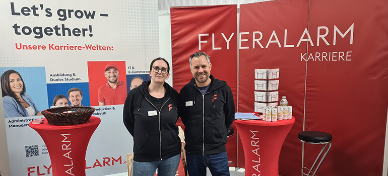 Zwei Personen am FLYERALARM Karriere-Stand auf der meineZukunft! Mainfranken Messe 2023.