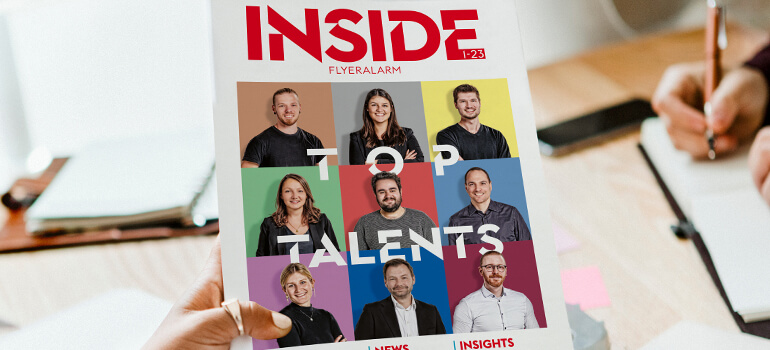 Person hält die neue Ausgabe des Flyeralarm-Magazins „INSIDE“ mit dem Titel Top Talents in der Hand.